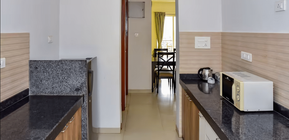 View from a bathroom towards a kitchen area at La Vida Studio Inn Goa.