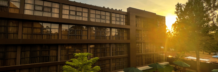 Facade of Boma Inn Eldoret at sunset with landscaped gardens, outdoor seating, and warm golden light creating a serene, inviting atmosphere.