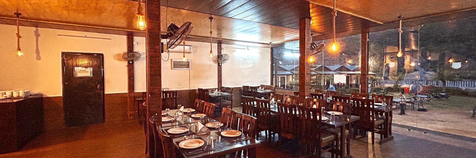 Dining area of the in-house restaurant at DLS MJ River Resort, Rishikesh.