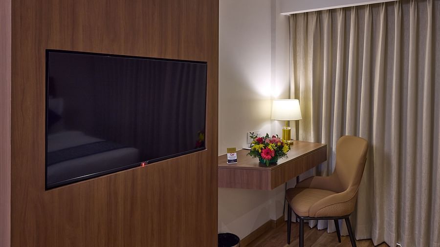 A work desk with a night lamp seen by the side of a wall-mounted television - Grand Continent, Brookefield