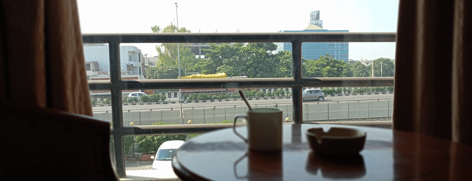 Sitting area at Hotel Gold, Panipat with a table and coffee mug on it.
