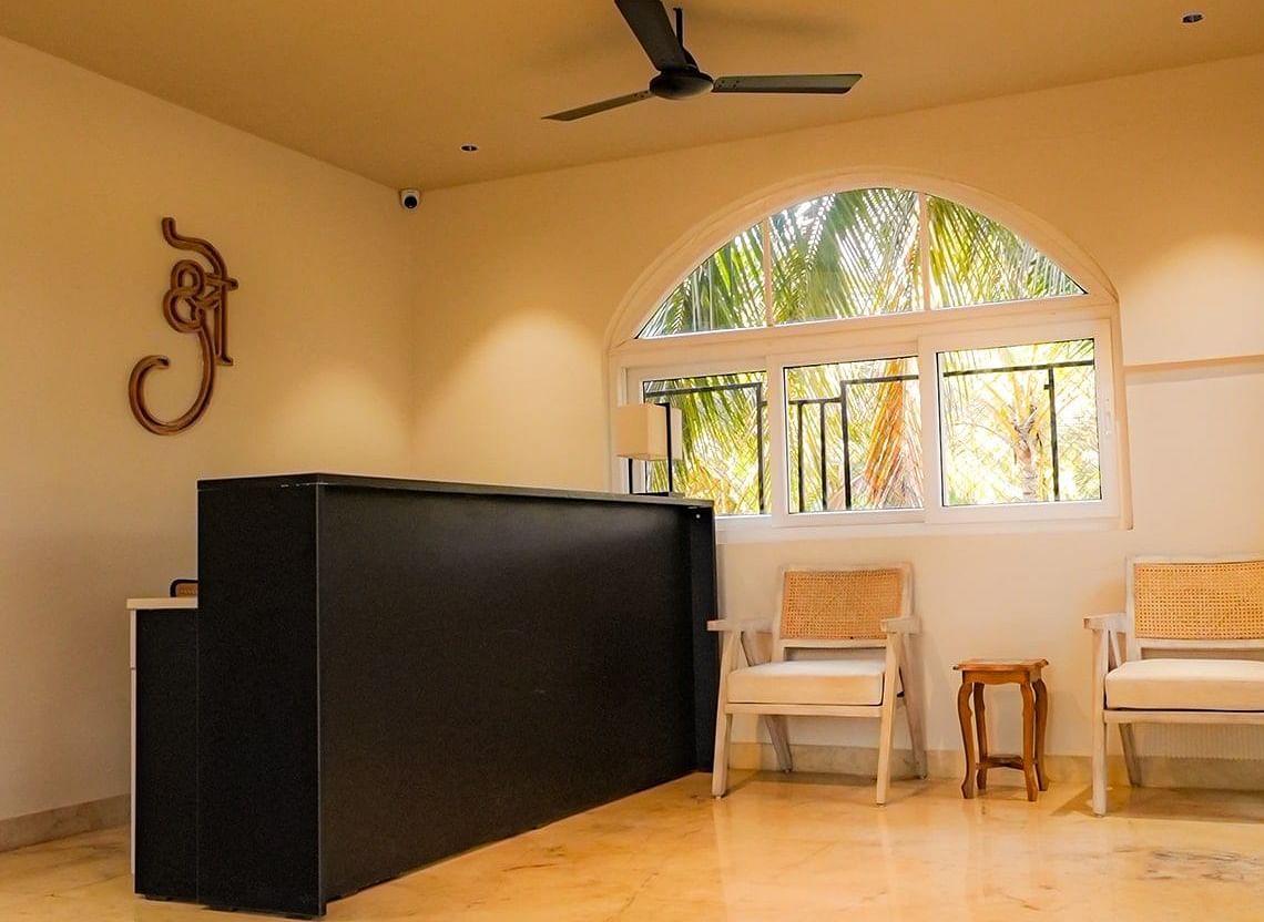A lobby area with a polished floor, a black front desk, and arched windows at Kssemya
