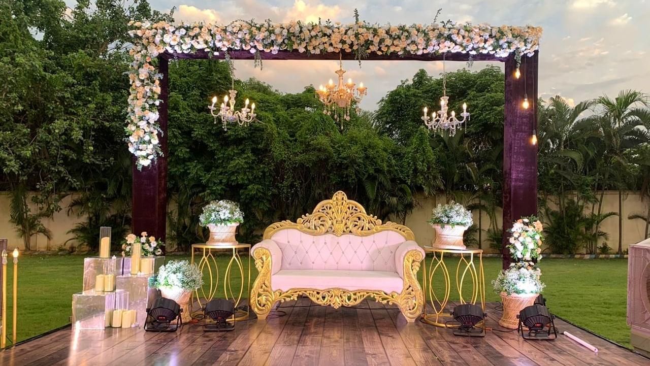 Ornate outdoor stage adorned with flowers and chandelier lighting at Ilara Hotels & Spa, OMR, Chennai