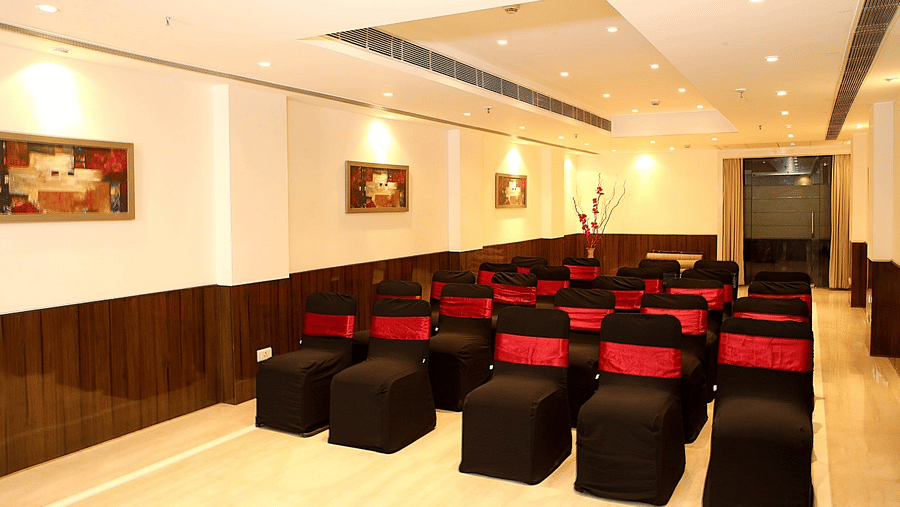 Rows of black chairs with red sashes face forward in a bright meeting room at Eastlynn Collections Huda City Centre.