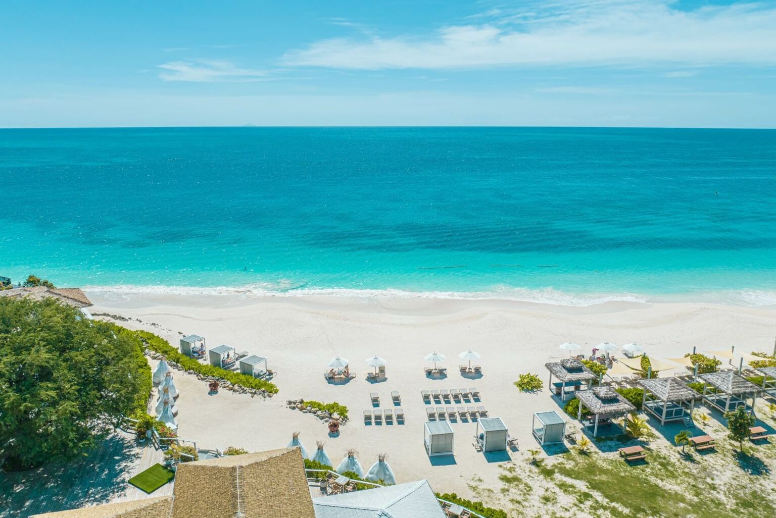 Aerial view of the white sand beach and turquoise waters at Tamarind Hills Antigua – Resort & Villas