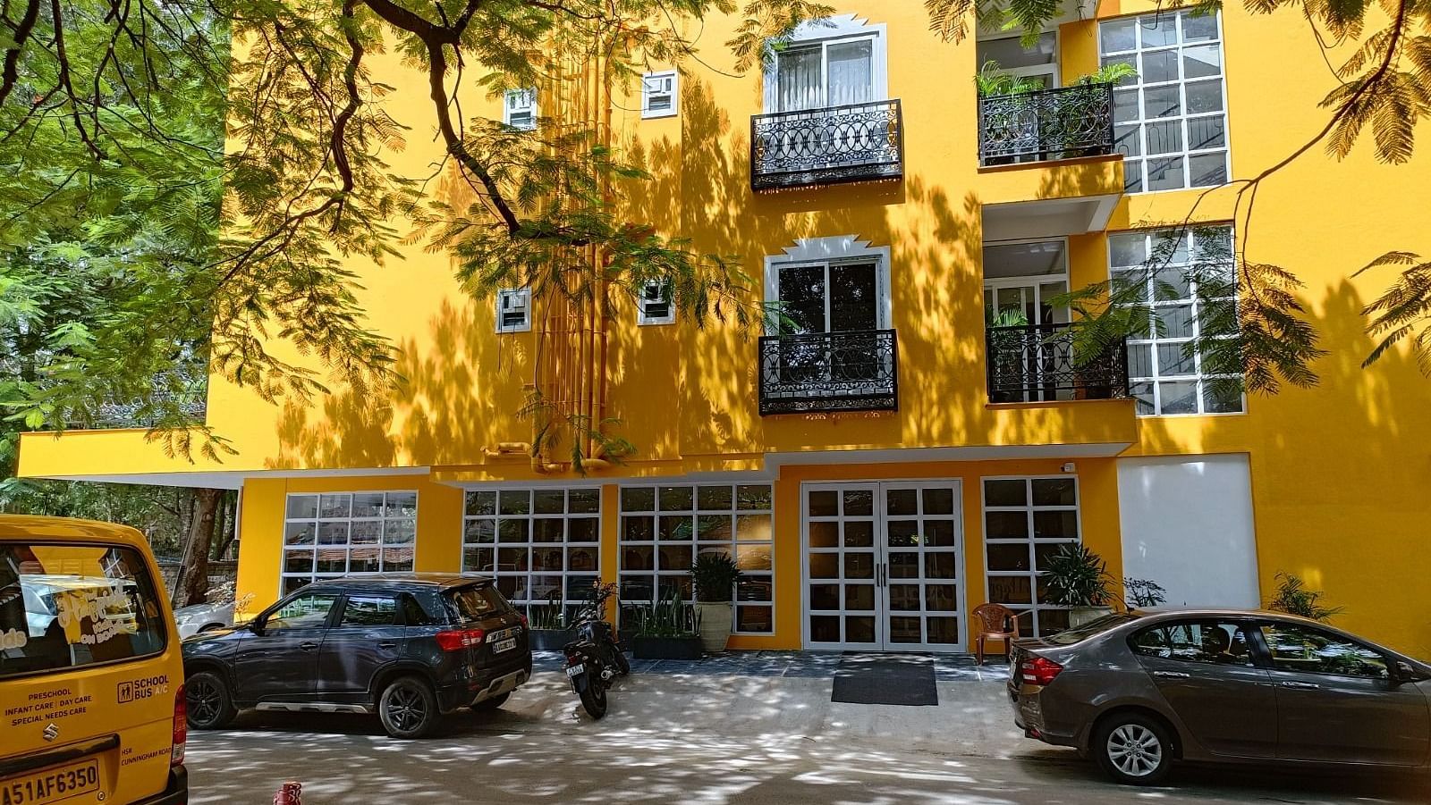 facade image of Astra Hotels and Suites in Koramangala with a bright yellow coloured exterior and beautiful windows