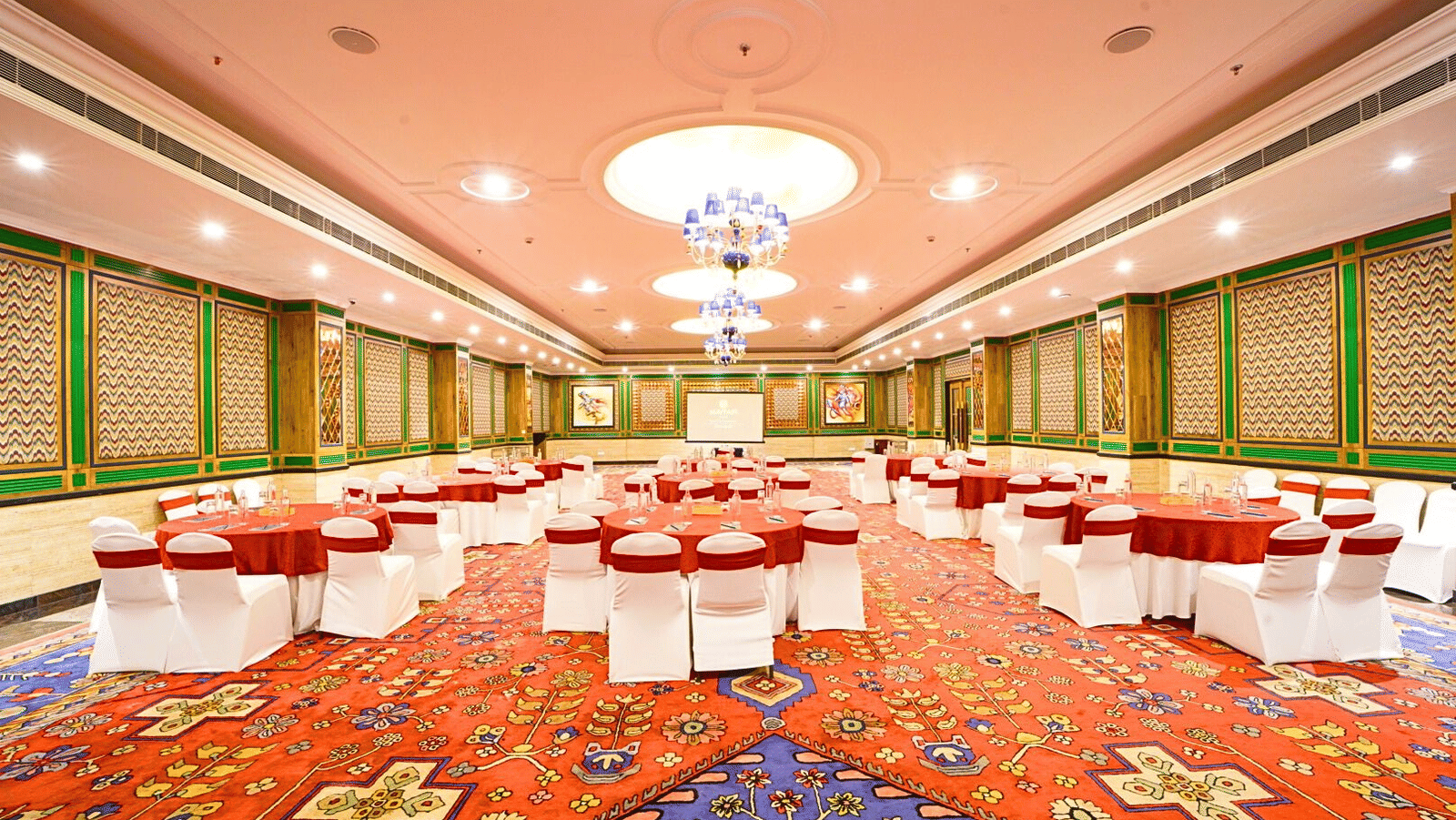 Elegantly decorated Orchid banquet hall with round tables at MAYFAIR Oasis Resort and Convention Jharsuguda