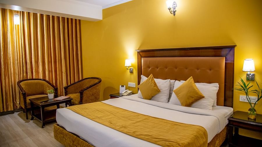 A room with a bed, 2 chairs and a coffee table | Sun Park Hotel & Banquet, Chandigarh - Zirakpuruxe Room-3