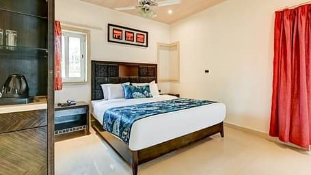  Generously sized bed accompanied by two wooden bedside tables and a large wooden wardrobe