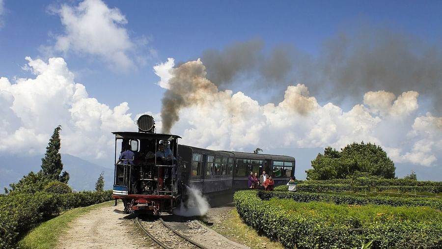 a train going on the tracks with smoking coming out of the chimney