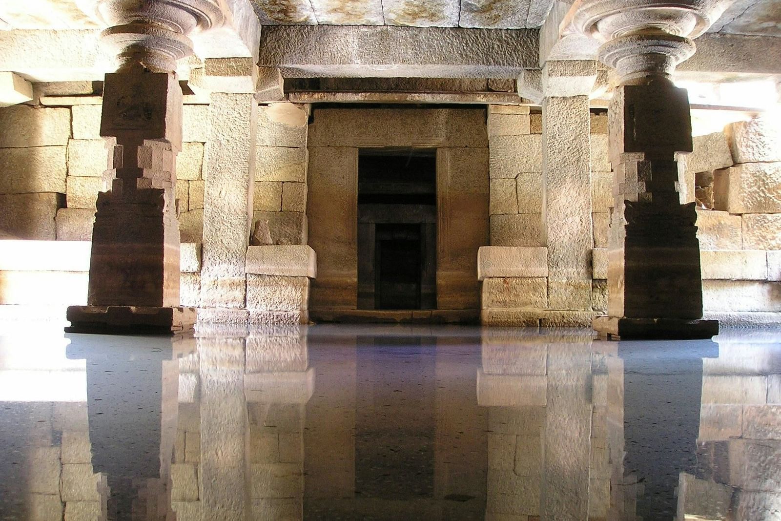 an image of a temple with pillars and water inside.