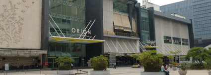 Facade of the Orion Mall in Bengaluru against an overcast sky in the background.