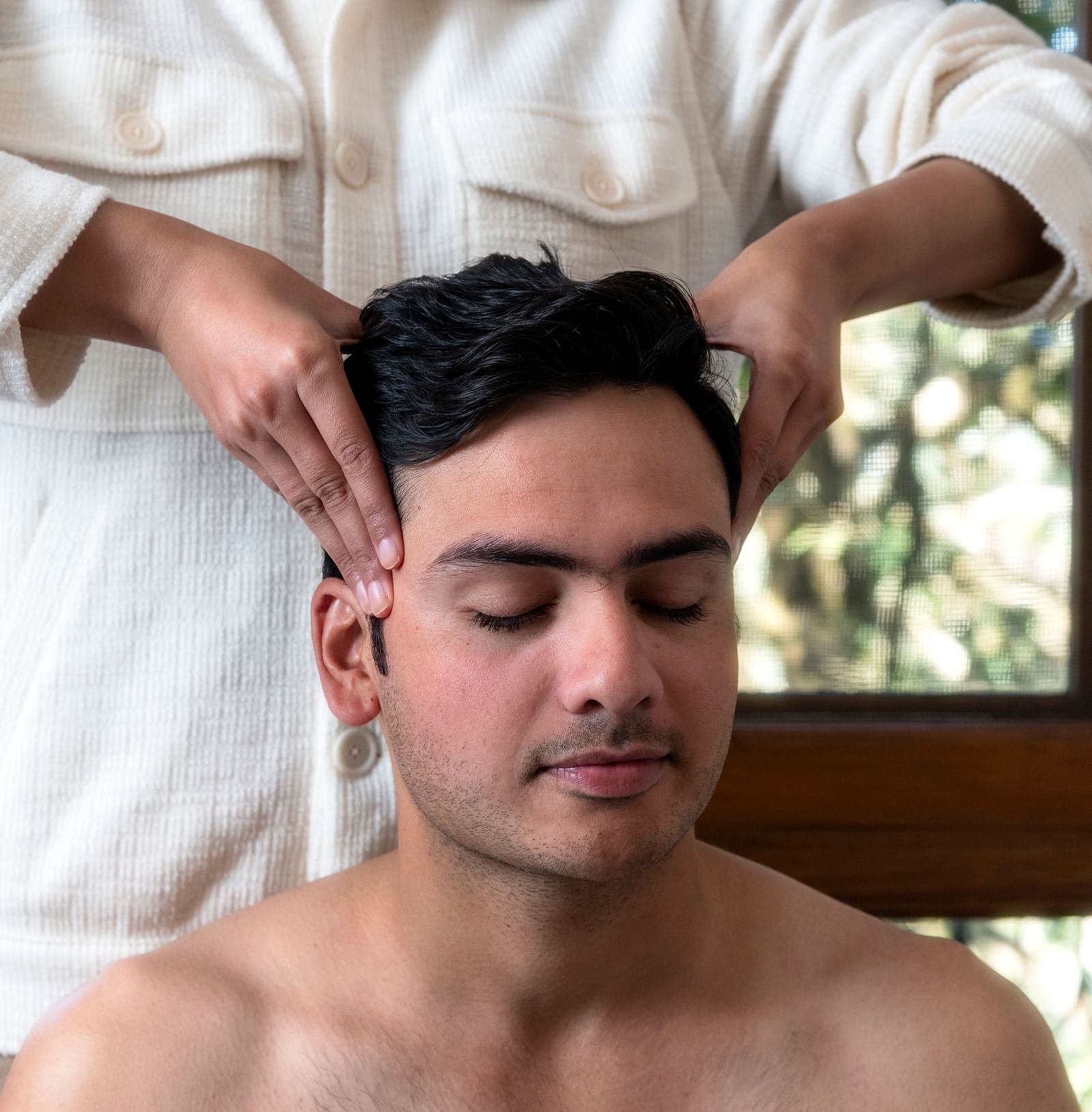 a person getting a head message at The Claridges Nabha Residence