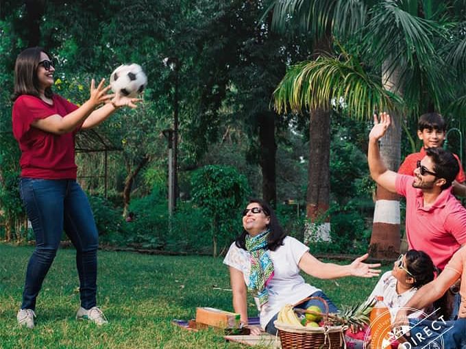 Family enjoying with a soccer ball midst a picnic