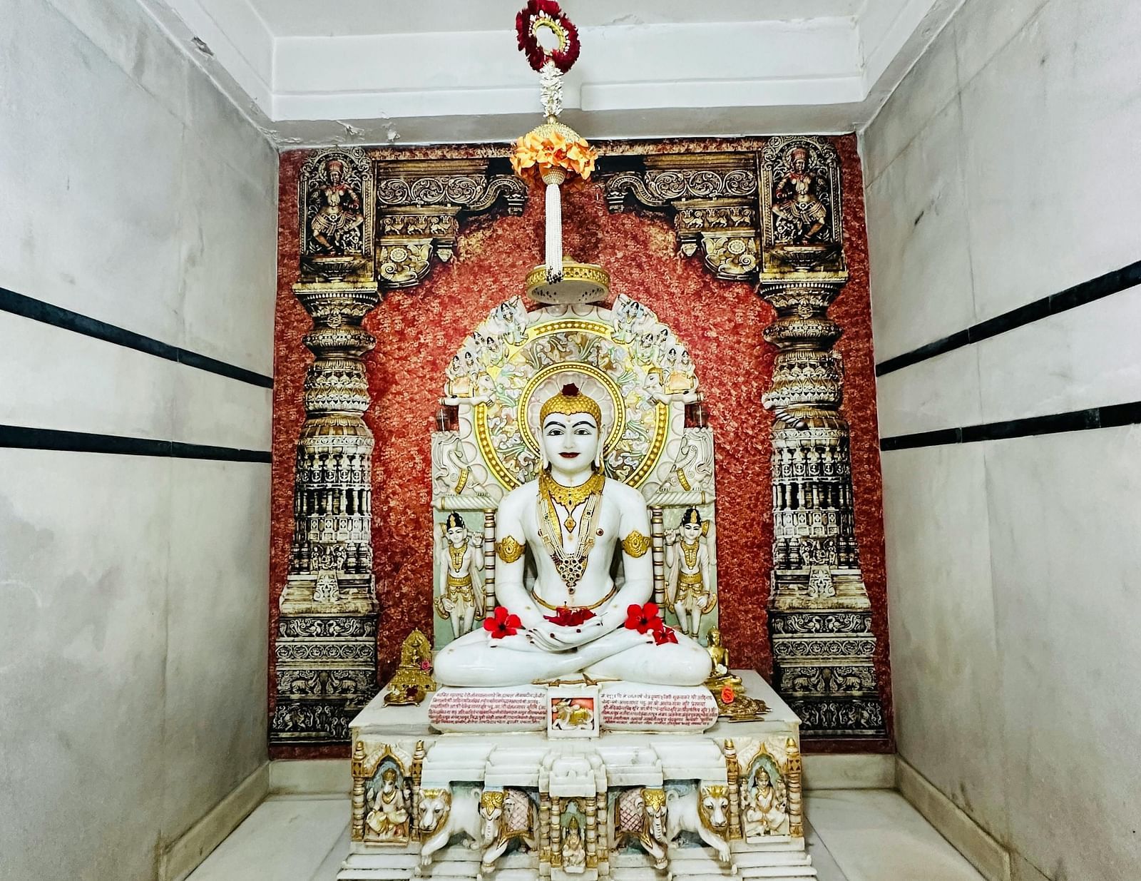 a statue of a Jain god made of white marble kept in a temple