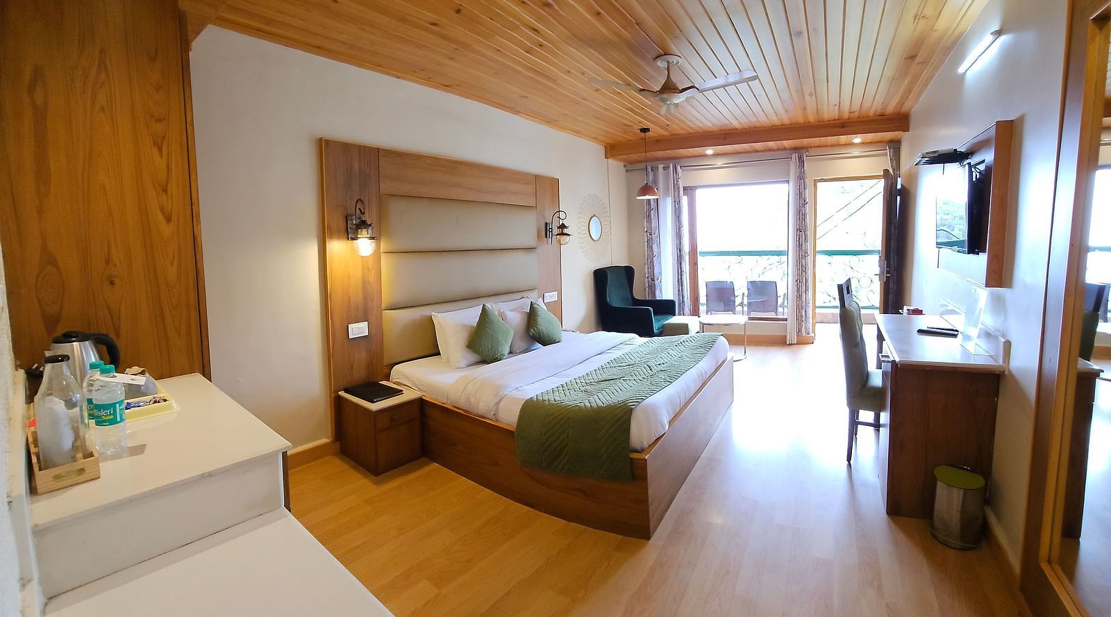 A full view of a room with a bed and glass windows offering views | Mongas Hotel & Resort, Dalhousie