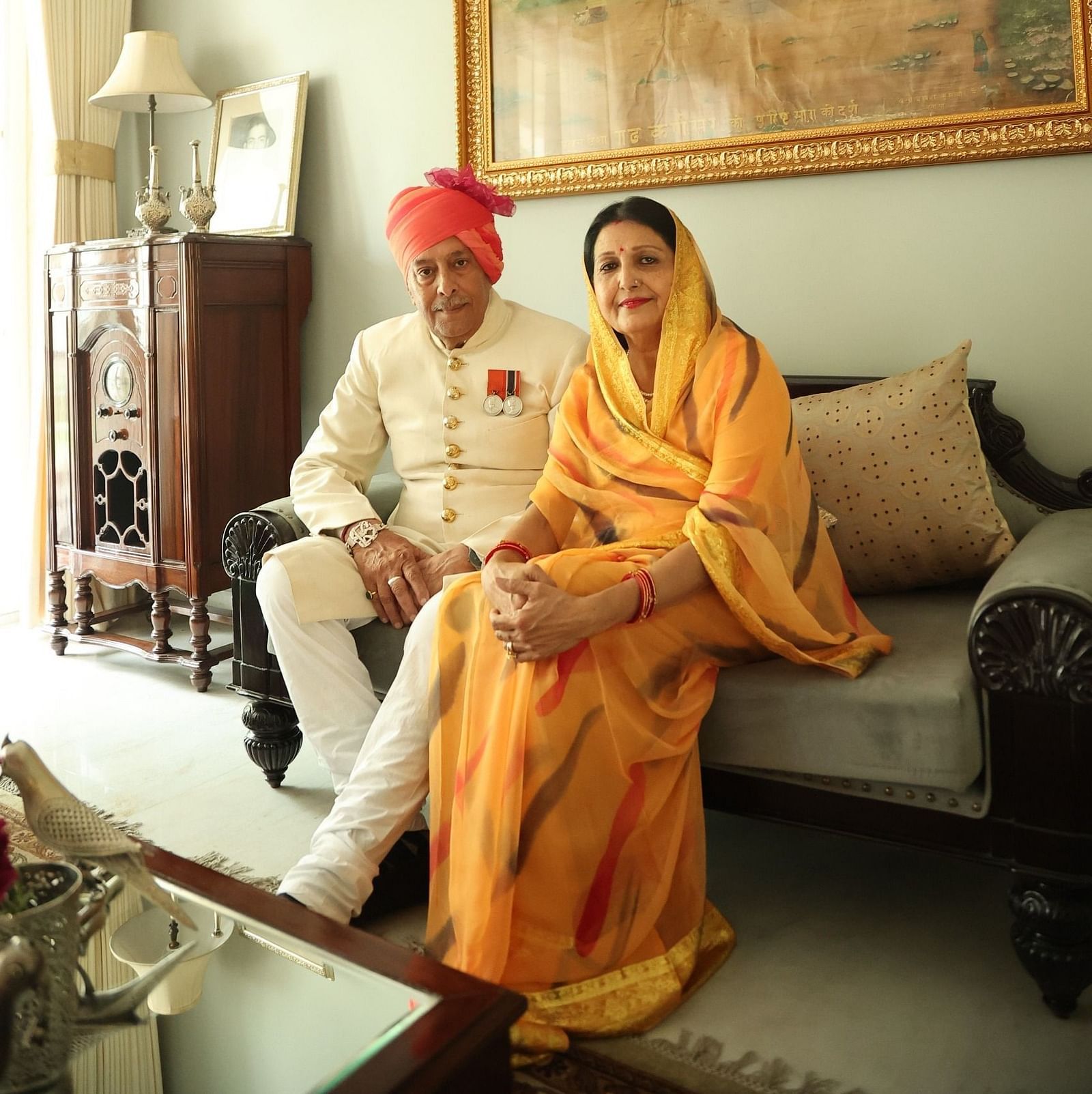 Mrs. Vinay Kumari & Mr. Umaid Singh Karansar sitting on a sofa in the lounge at Dileep Kothi, Jaipur