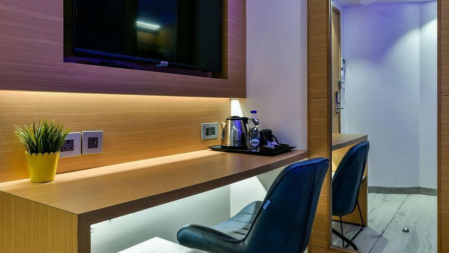 A wooden desk with a pair of chairs and a wall-mounted TV above, at Indie Stays, BKC Kalina.