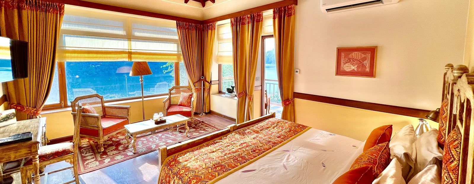 A comfortable Superior Lake Facing Room at Fishermen's Lodge, Bhimtal, with an open window allowing sun rays to illuminate the space.