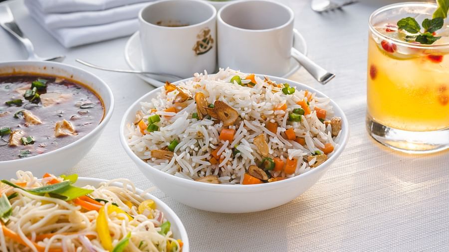A dining table set with cups and delicious food with a refreshing beverage at The Claridges Nabha Residence