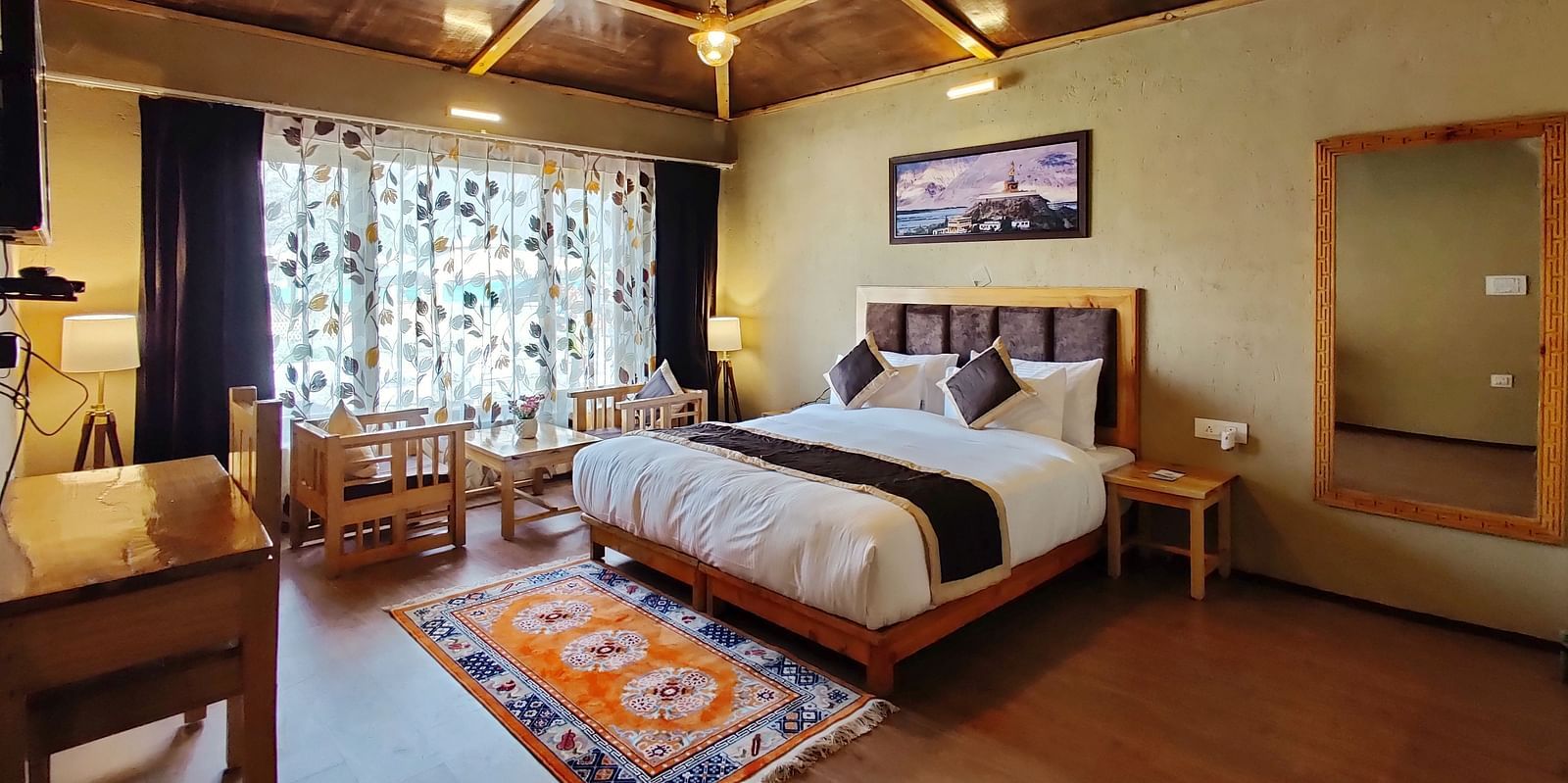 Premium Cottage at White Sands Resort, Ladakh , showcasing a king size bed, wooden accents, and a rug with a different pattern.