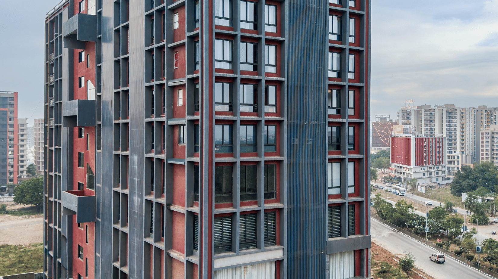 Exterior view of the multi-storey hotel building along the city road - Pride Elite Gandhinagar