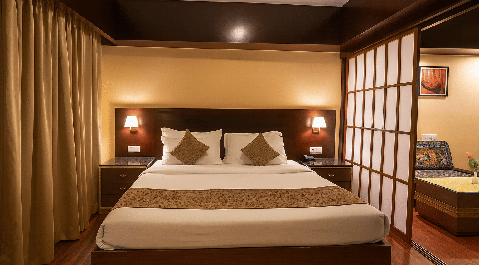 Premium 3-star hotel room in Gangtok with king-size bed, warm ambient lighting, elegant wooden interiors, and a cozy sitting area separated by shoji-style panels