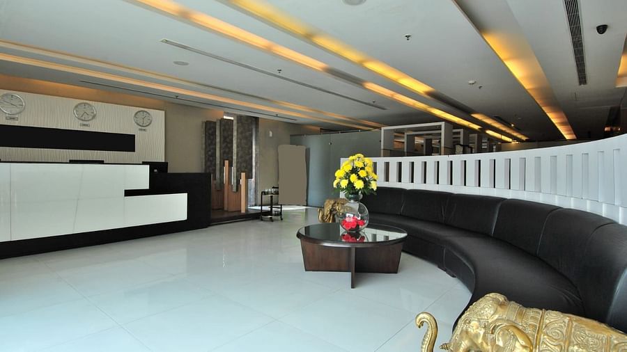 A lobby with a curved sofa, reception desk, and decorative elements, showcasing a stylish interior - VITS Gurugram