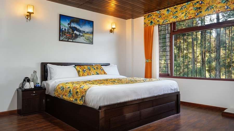 Image of a room with bed and wooden ceiling and flooring at Summit Sherpa Mountain Hotel & Spa, Kalimpong