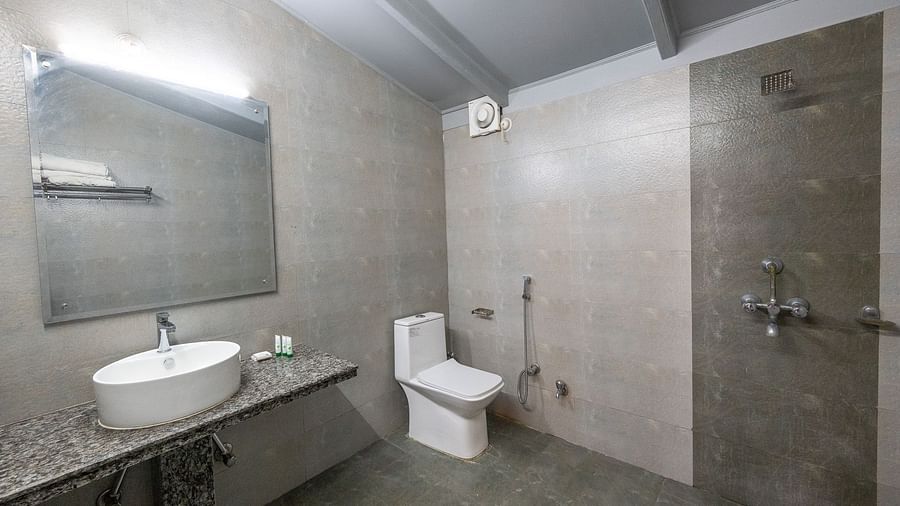 Washroom with a sink and a wall-mounted mirror at Himalaya Hotel, Nainital