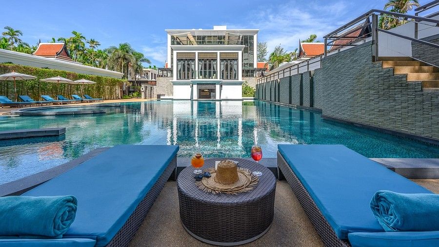 image featuring a table between two sun loungers facing towards the swimming pool with refreshing beverages placed on the table - Maikhao Dream Villa Resort & Spa, Phuket