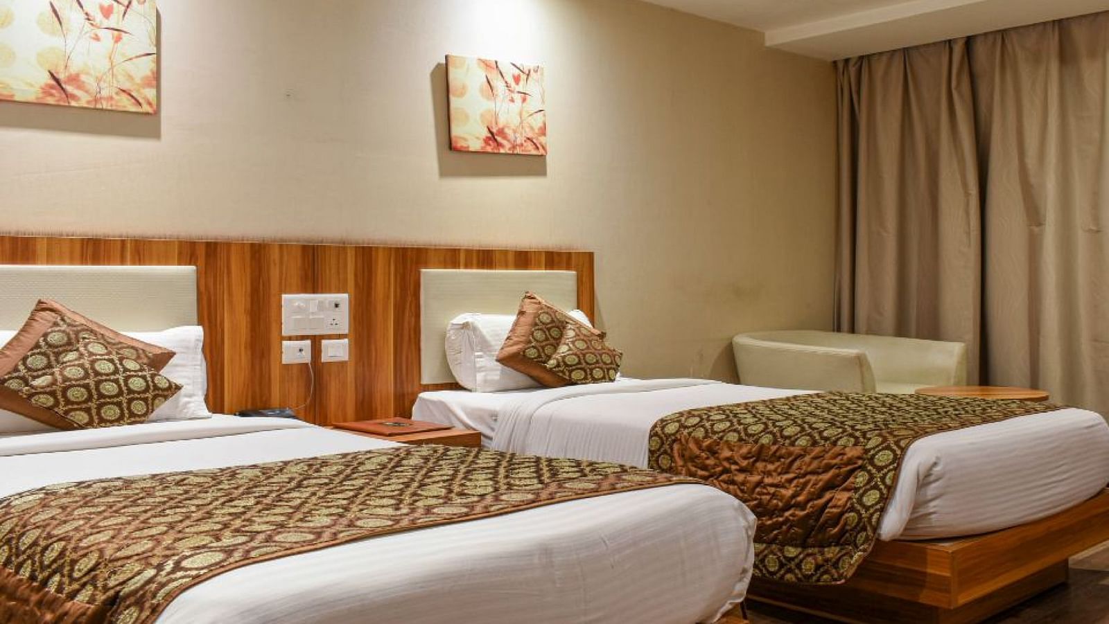 corporate room with twin beds and warm lighing at le roi raipur hotel