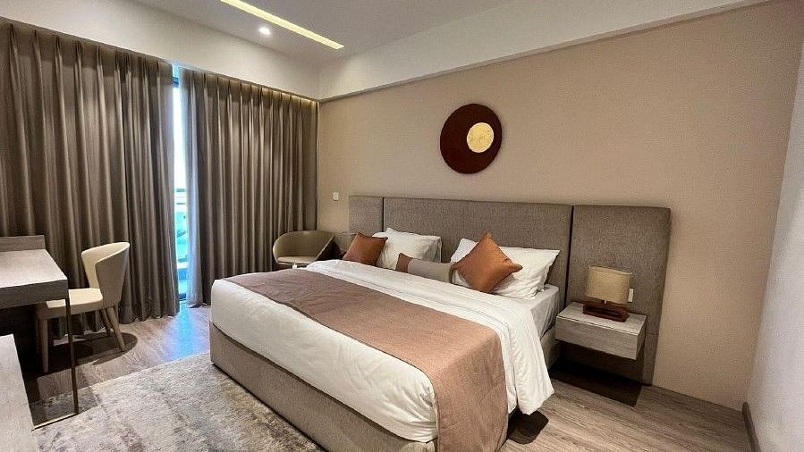 Image of a room with bed and ceiling to floor curtains.