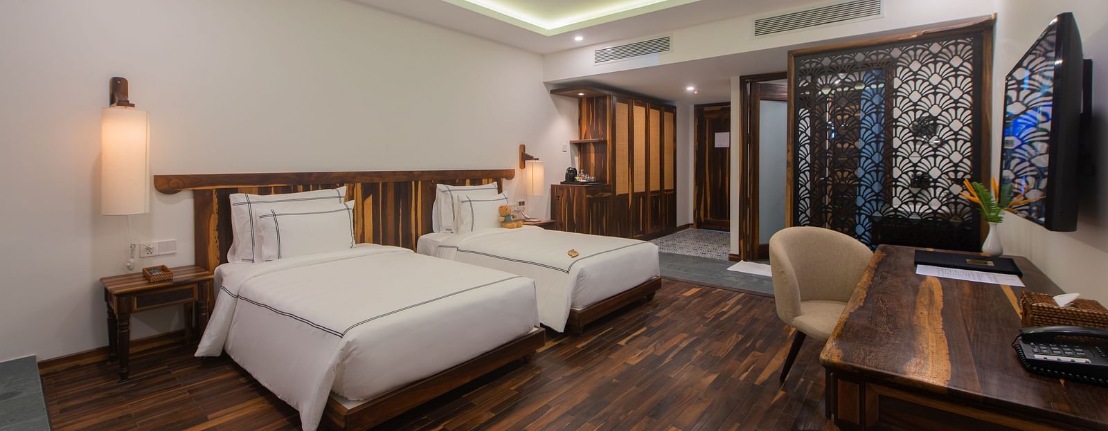 A rustic room with twin beds, ambient lighting and comfortable furniture - Alibu Resort Nha Trang