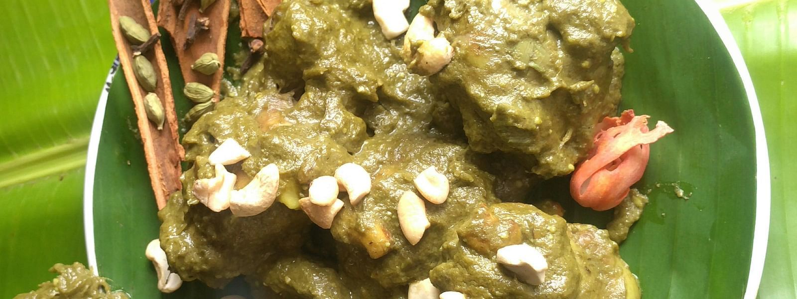 A traditional dish of chicken cooked in a rich, spicy gravy, garnished with almonds and served on a banana leaf for an authentic flavour - The President Hotel Jayanagar, Bangalore