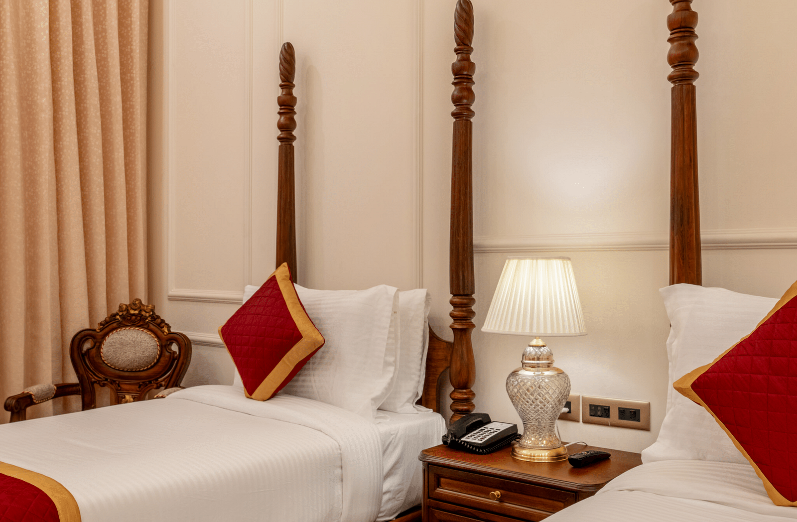 corner view image of a twin bed with a bed side lamp in the middle of them - Brij Castle, Jaipur