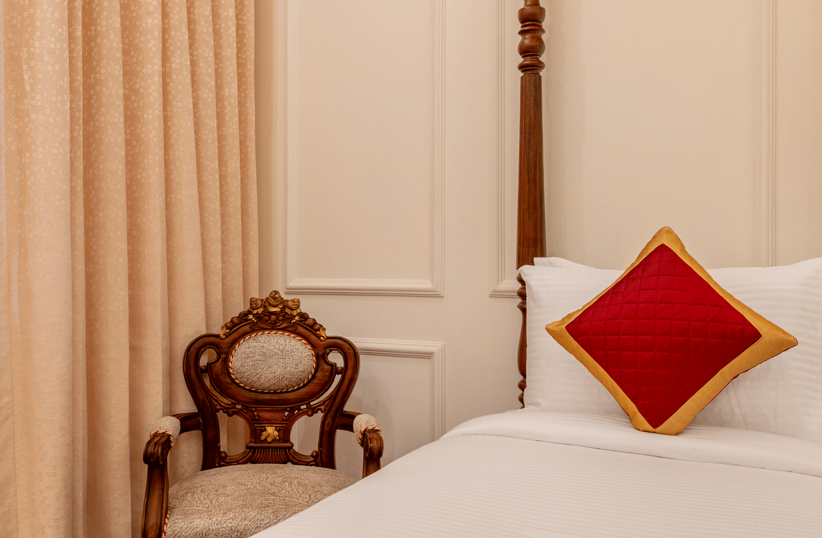 a cushioned armchair placed in the corner of the room besides a single bed - Brij Castle, Jaipur