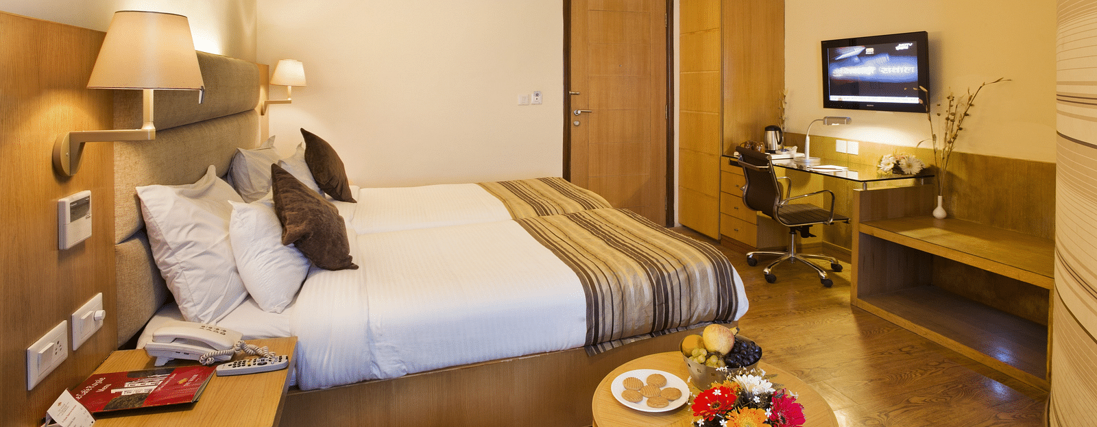 an image of a side view of the deluxe bedroom with a television at The Manor, Bareilly