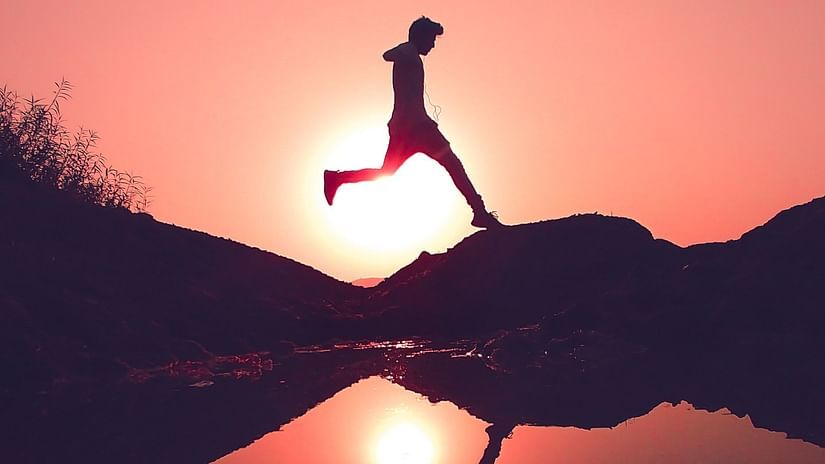a man running with his reflection on water