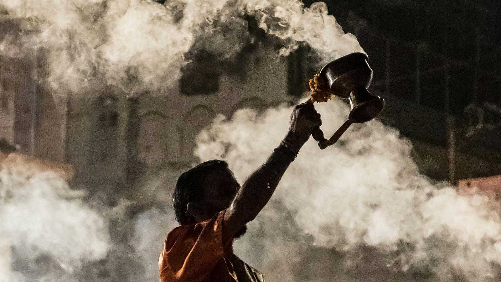 image of a temple priest offering prayers and performing aarti