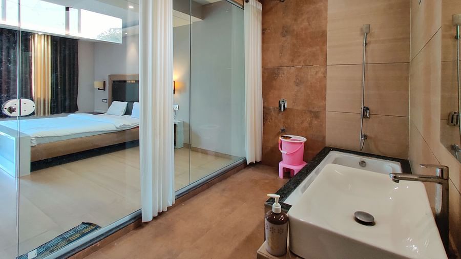 Bathroom of Super Premium Room at The Kanila  Resort  featuring a bathtub in the corner along with shower area.
