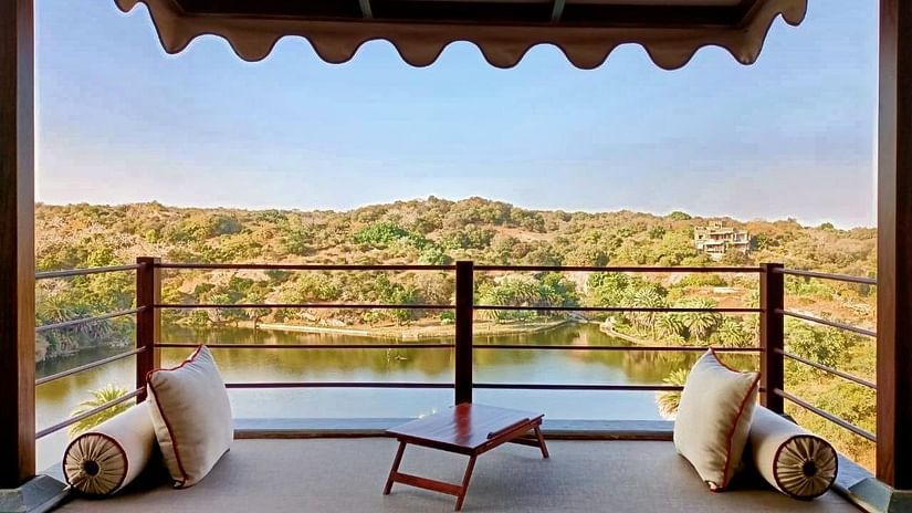cushions and a table on the Balcony with lake and forest in the background inside one of the rooms - Chunda Shikar Oudi