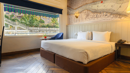 Double bed room at Polo Floatel Kolkata with blue blinds, river view window, and a detailed mural above the bed.