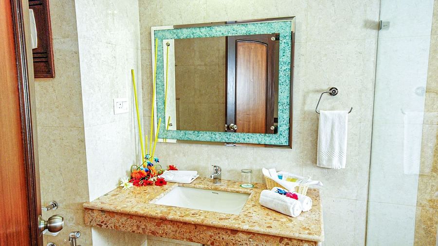A sink and a mirror on the wall in a washroom Sun Park Hotel & Banquet, Chandigarh - Zirakpur