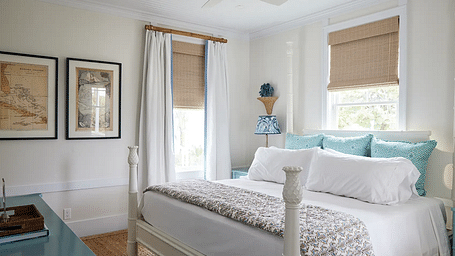 Bright bedroom with a four-poster bed, framed art, and a ceiling fan | Abaco Inn