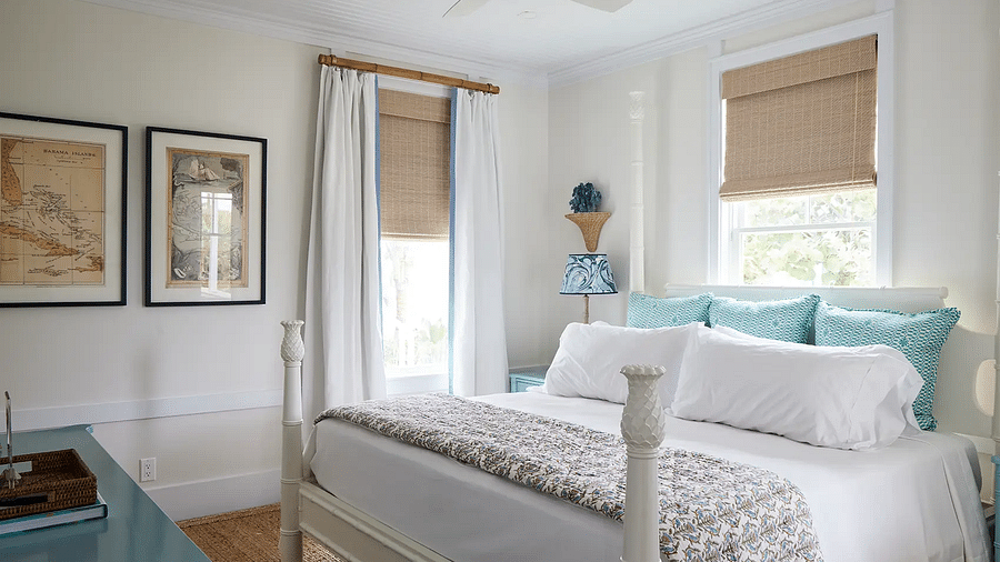 Bright bedroom with a four-poster bed, framed art, and a ceiling fan | Abaco Inn
