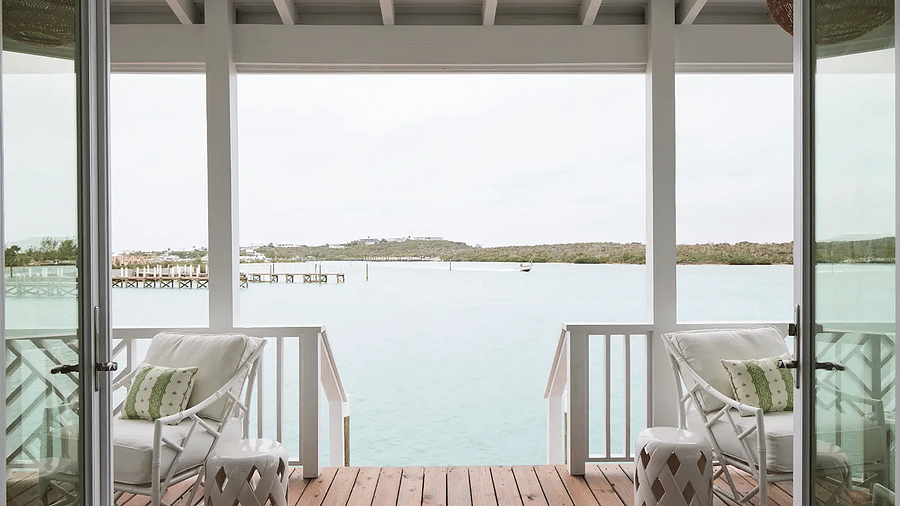 Waterfront balcony with white chairs overlooking the ocean | Abaco Inn