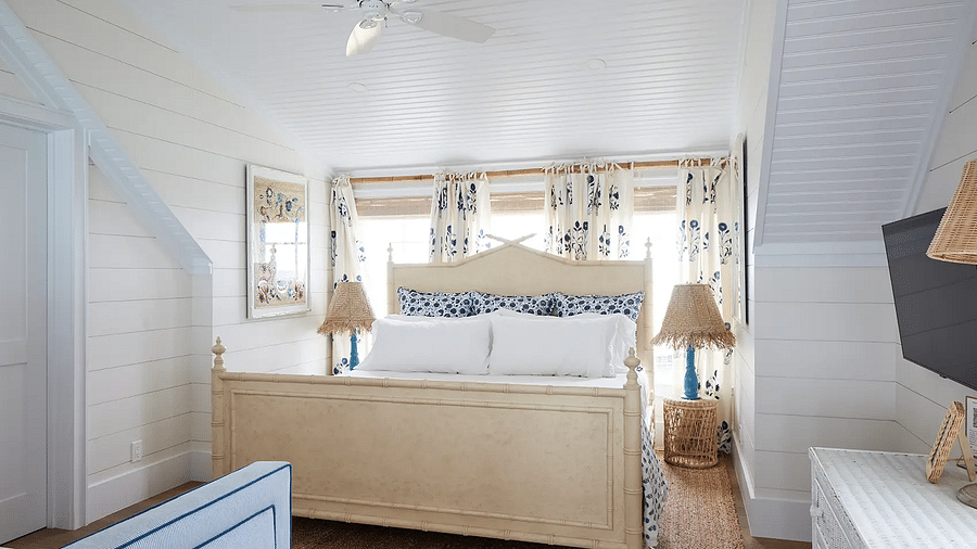 Bedroom with a wooden bed frame, neutral bedding, and framed artwork | Abaco Inn