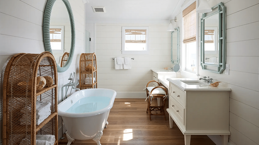 Bathroom with a freestanding bathtub, vanity, and a round mirror | Abaco Inn