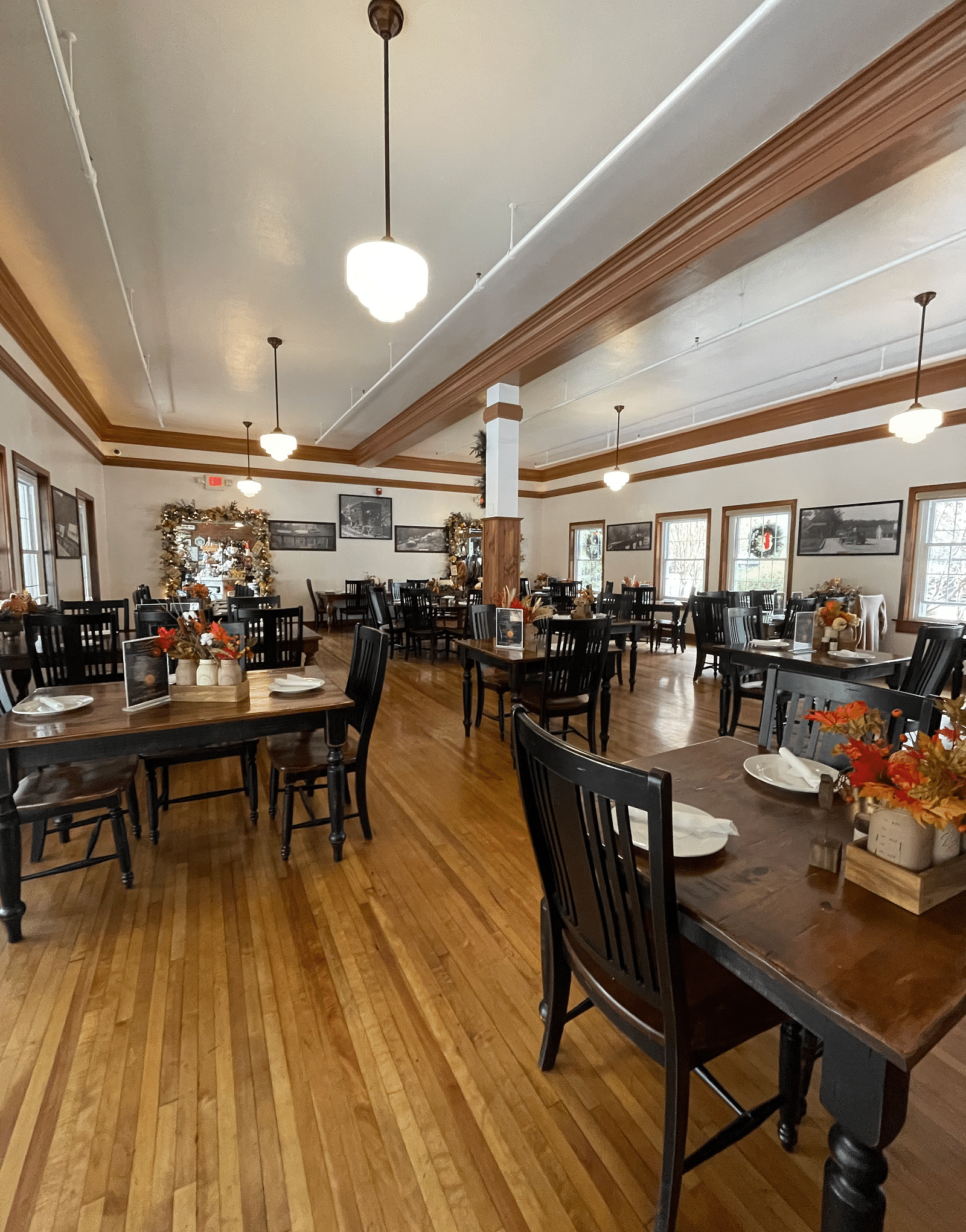 a wide angle shot of the Cheoah Dining Room with wooden flooring and rustic dining tables with crockery placed on them - Historic Tapoco Lodge